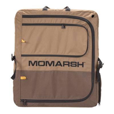 The MOmarsh Quick Crate by MOmarsh Inc. is a brown and tan soft-sided portable dog crate with black zippers, handles, large front branding, and multiple pockets for storage.